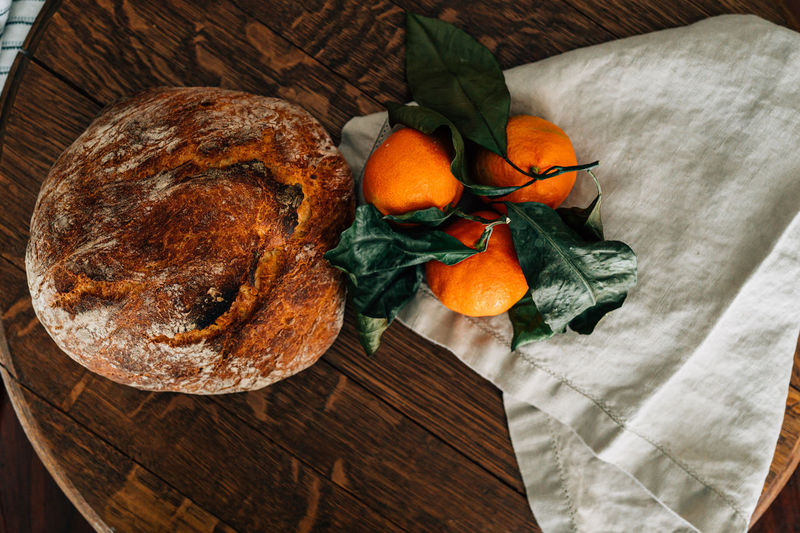 Rustic bread loaf and clementines on the vine