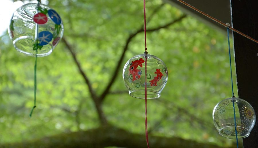 Low angle view of japanese wind bell hanging on rope