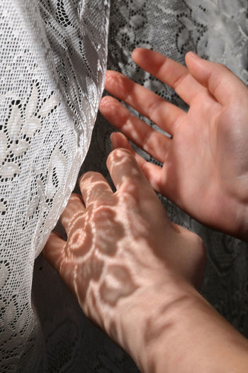 Close-up of hands on curtain
