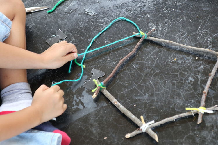 High angle view of person tying sticks on floor