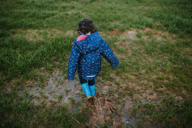 Rear view of girl walking on field