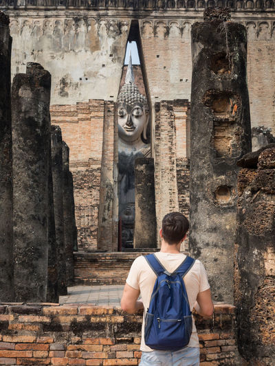 Rear view of man standing against ancient temple