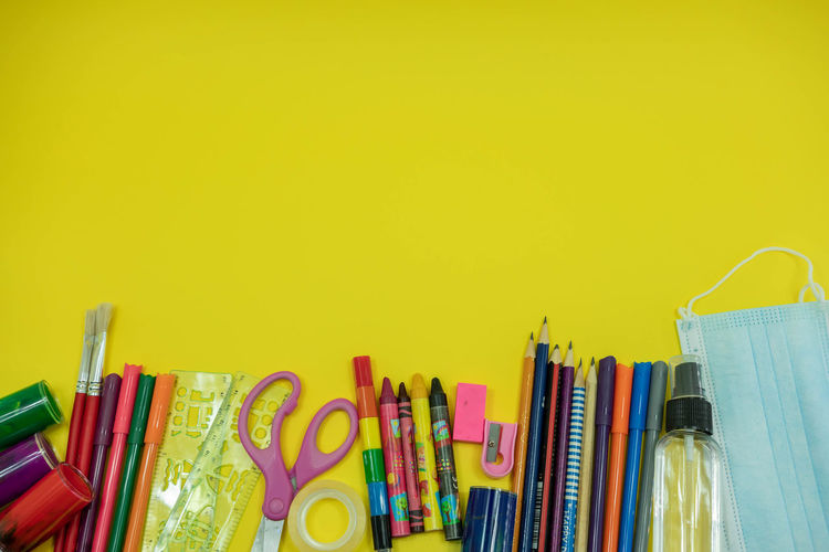Close-up of multi colored pencils against yellow background