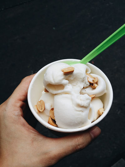 Close-up of hand holding coconut ice cream
