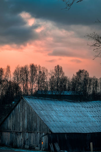 Houses and trees against sky during sunset