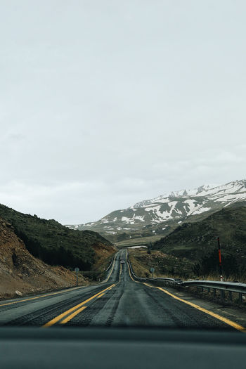 Road against sky seen through car windshield