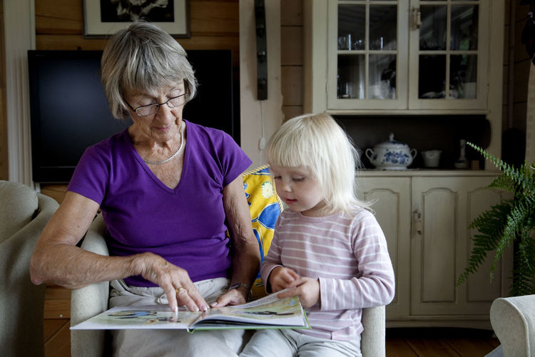 Grandmother reading granddaughter book
