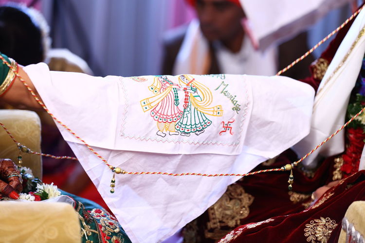 Close-up of textile on bride and bridegroom hands during wedding ceremony