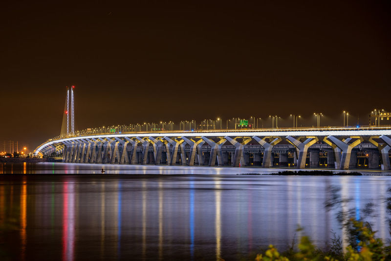 Illuminated champlain bridge over river at night