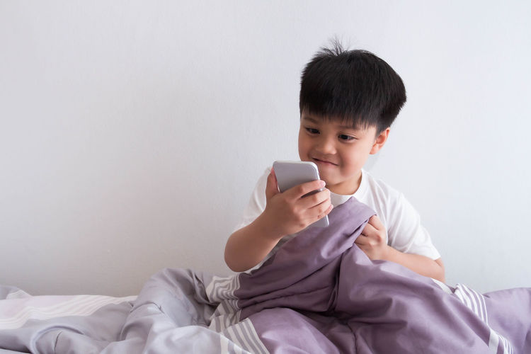 Man using mobile phone on bed