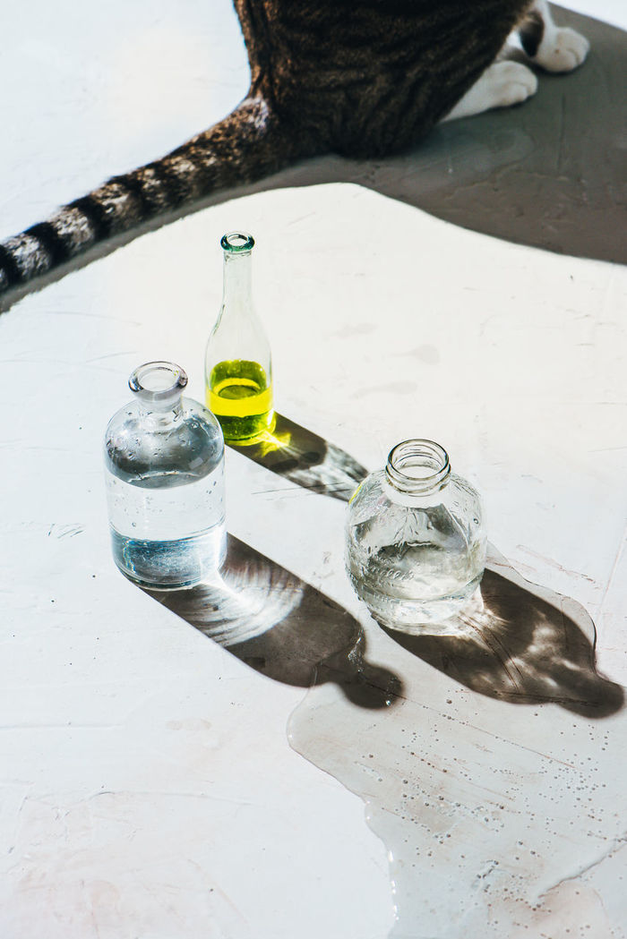 HIGH ANGLE VIEW OF BOTTLE IN GLASS ON TABLE