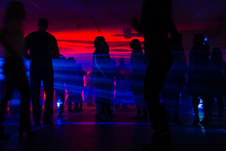 Silhouette people in illuminated nightclub