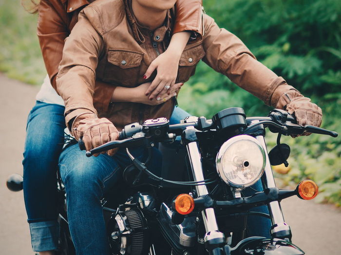 Midsection of couple on motorcycle
