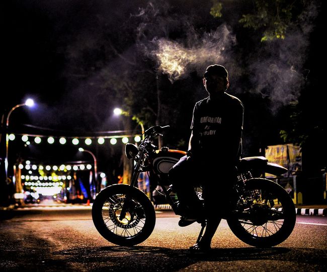 Full length of man sitting on motorcycle at night
