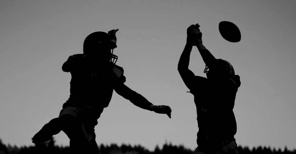 Silhouette people playing with ball against sky