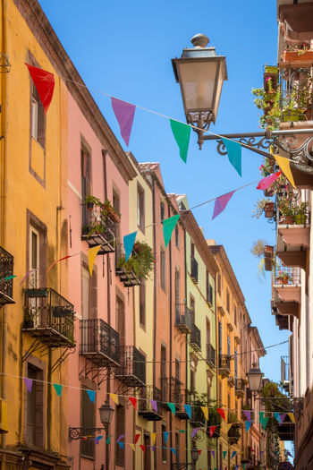Colorful garland decoration in the old town of bosa on the italian island of sardinia against sky