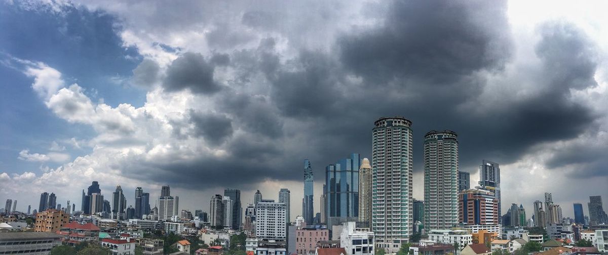 Panoramic view of cityscape against dramatic sky