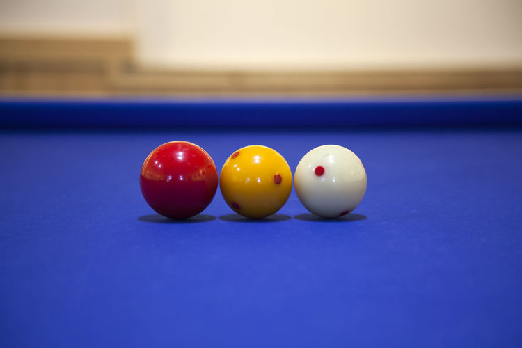 Close-up of cue balls on blue billiards table