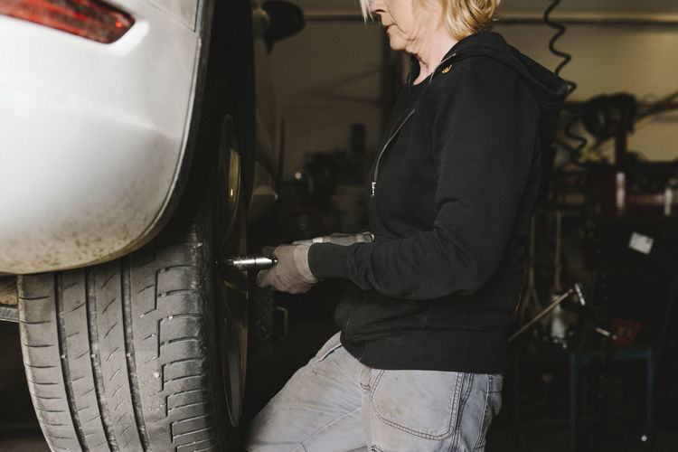 Female mechanic repairing car