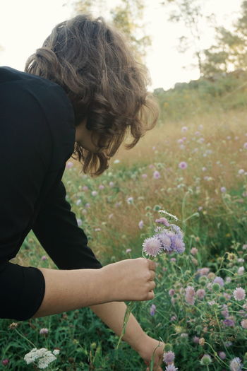 Girl picking flowers on field