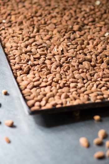 High angle view of scattered almonds on table with baking sheet at bakery