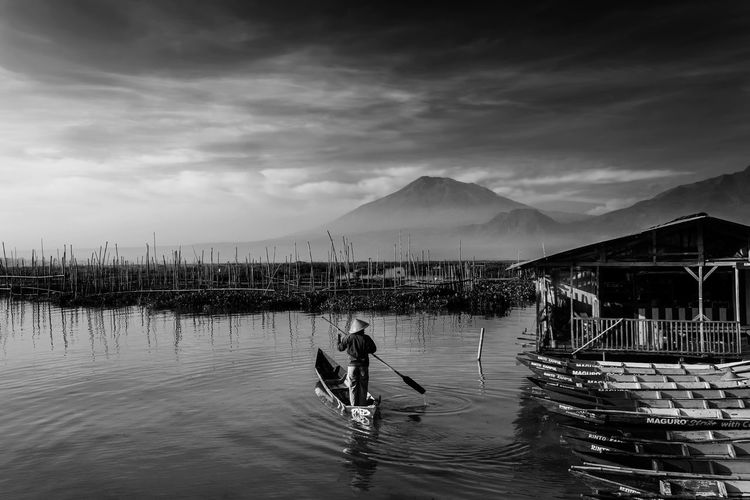 Man standing on shore against sky