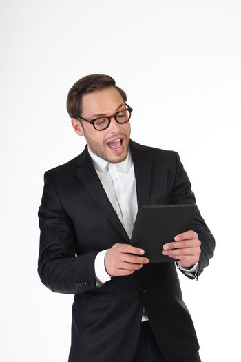 Young man using smart phone against white background