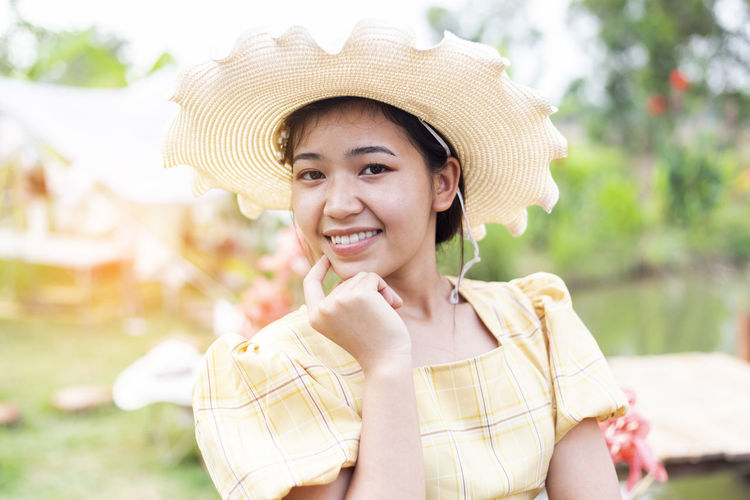 Portrait of smiling young woman wearing hat
