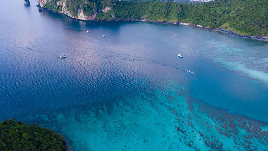 Aerial drone view of tropical ko phi phi island, and boats passenger in blue clear andaman sea 
