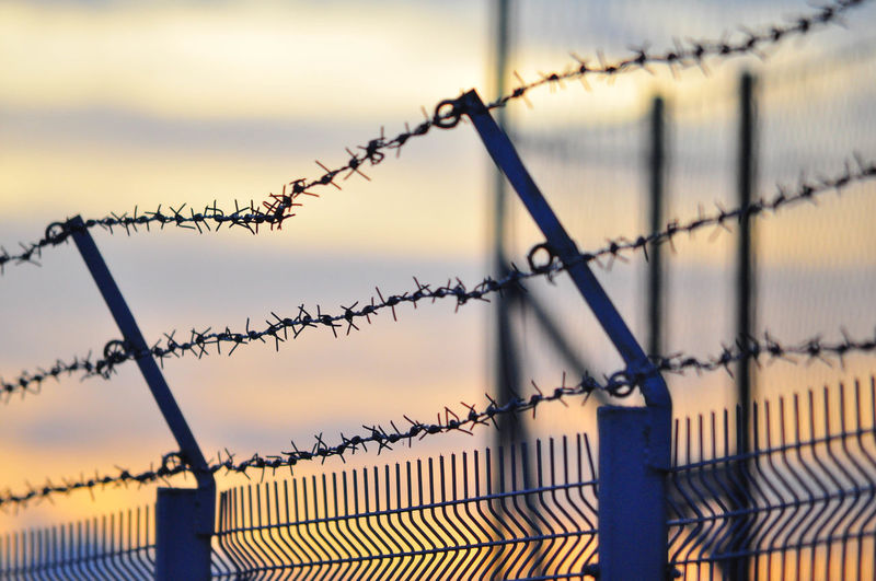 Close-up of barbed wire against sky