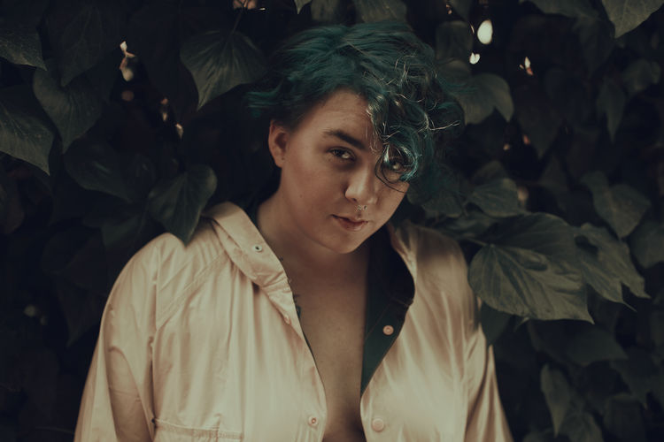 Portrait of young woman looking away. blue hair. natural light portrait