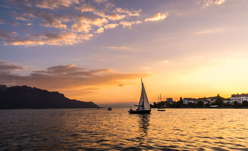 Boat sailing in sea at sunset