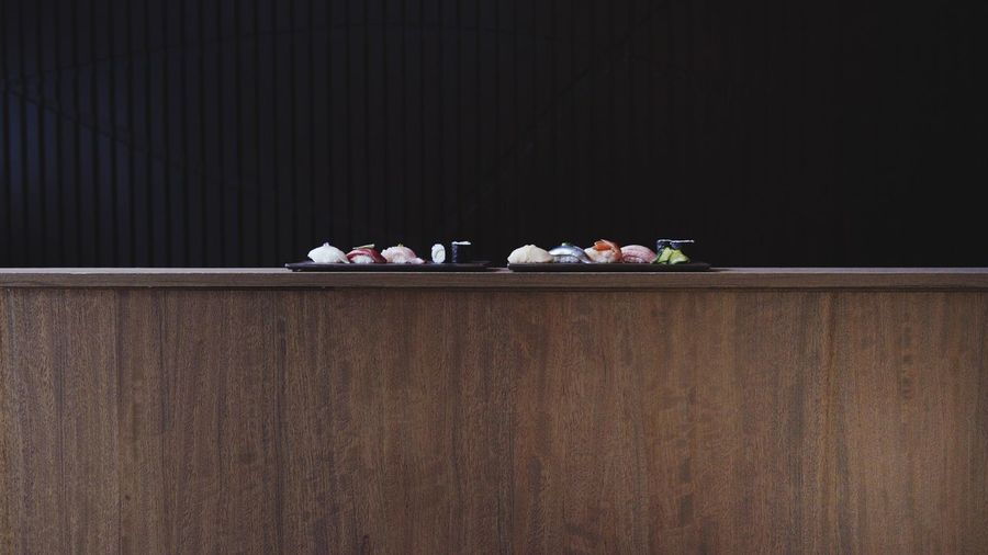 Sushi served in trays on wooden table