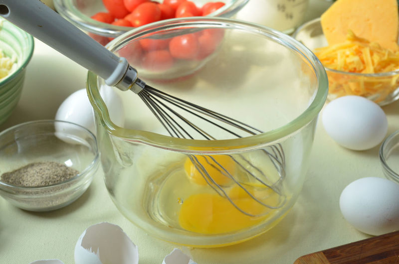 Close-up of egg yolk with wire whisk in container