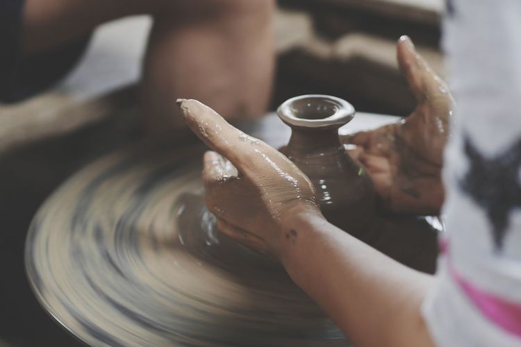 Cropped image of woman working on pottery wheel