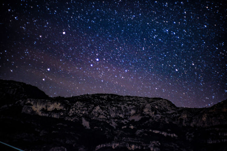 Scenic view of mountains against star field at night