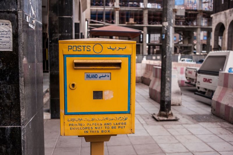 Yellow public mailbox on footpath