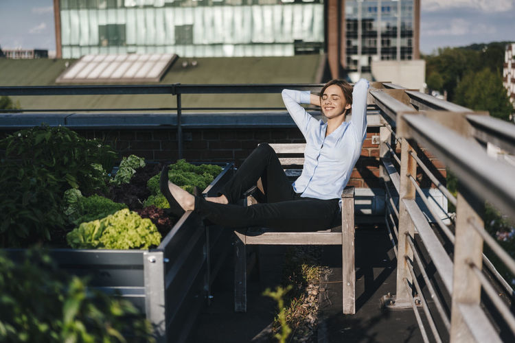 Businesswoman relaxing in his urban rooftop garden