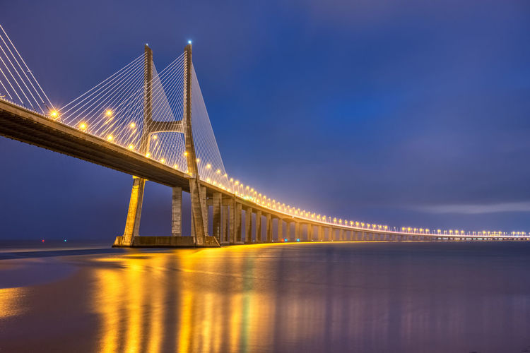 The imposing cable-stayed vasco da gama bridge across the river tagus in lisbon, portugal, at night