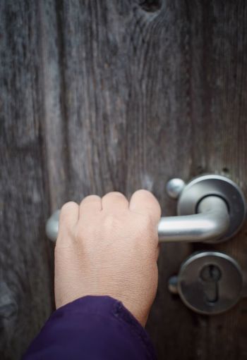 Cropped hand holding door handle