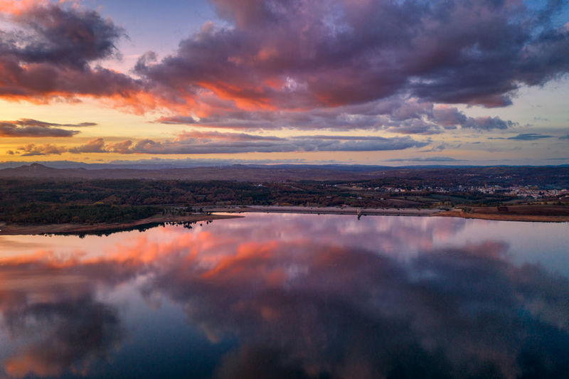 Drone aerial view of a lake reservoir of a dam with reflection on the water in sabugal, portugal