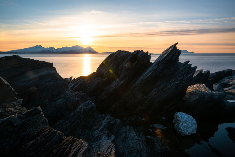Rock formation at a fjord landscape in northern norway on a warm summer evening with midnight sun