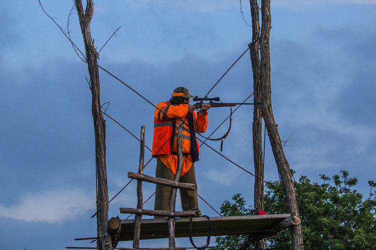Rear view of man working against sky