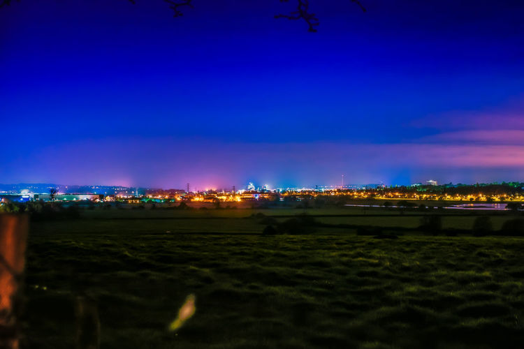 Illuminated park against sky at night