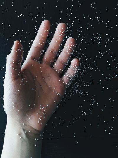 Close-up of hand with polystyrene over black background