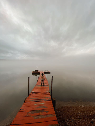 Boy on foggy dock