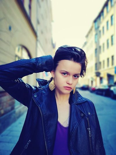 Portrait of beautiful young woman with buildings in background