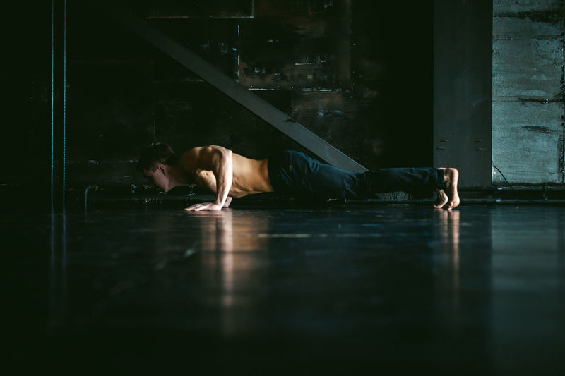 Shirtless man exercising on floor