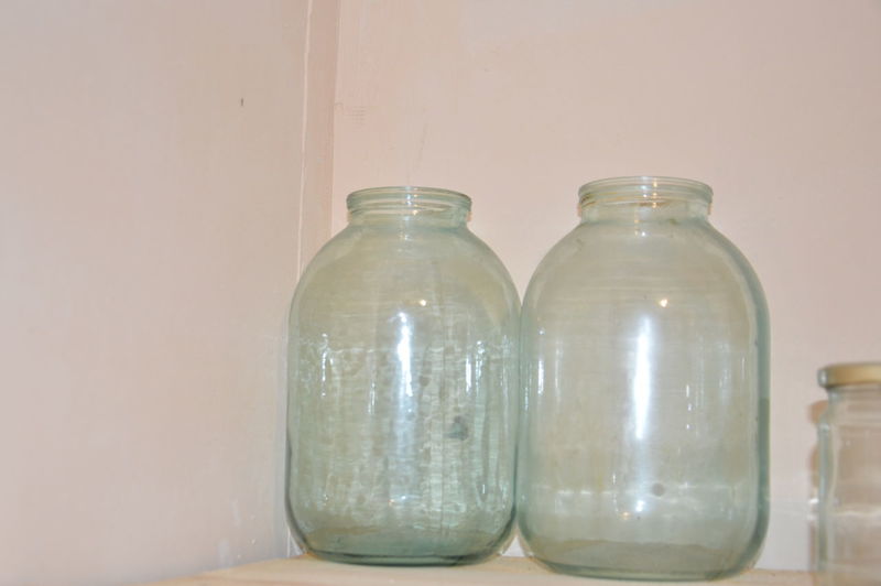 Close-up of glass jar on table against wall
