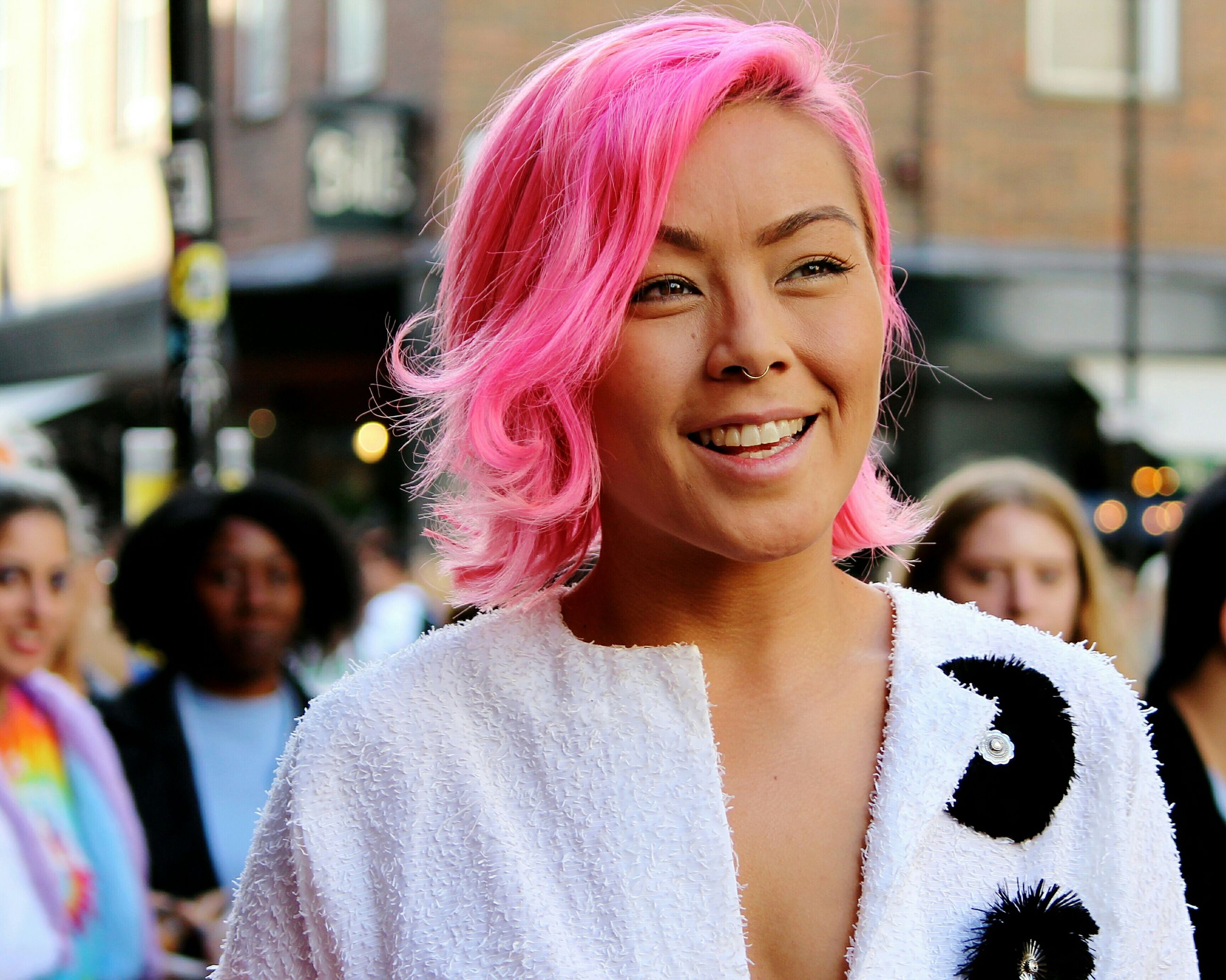 PORTRAIT OF HAPPY YOUNG WOMAN WITH PINK HAIR